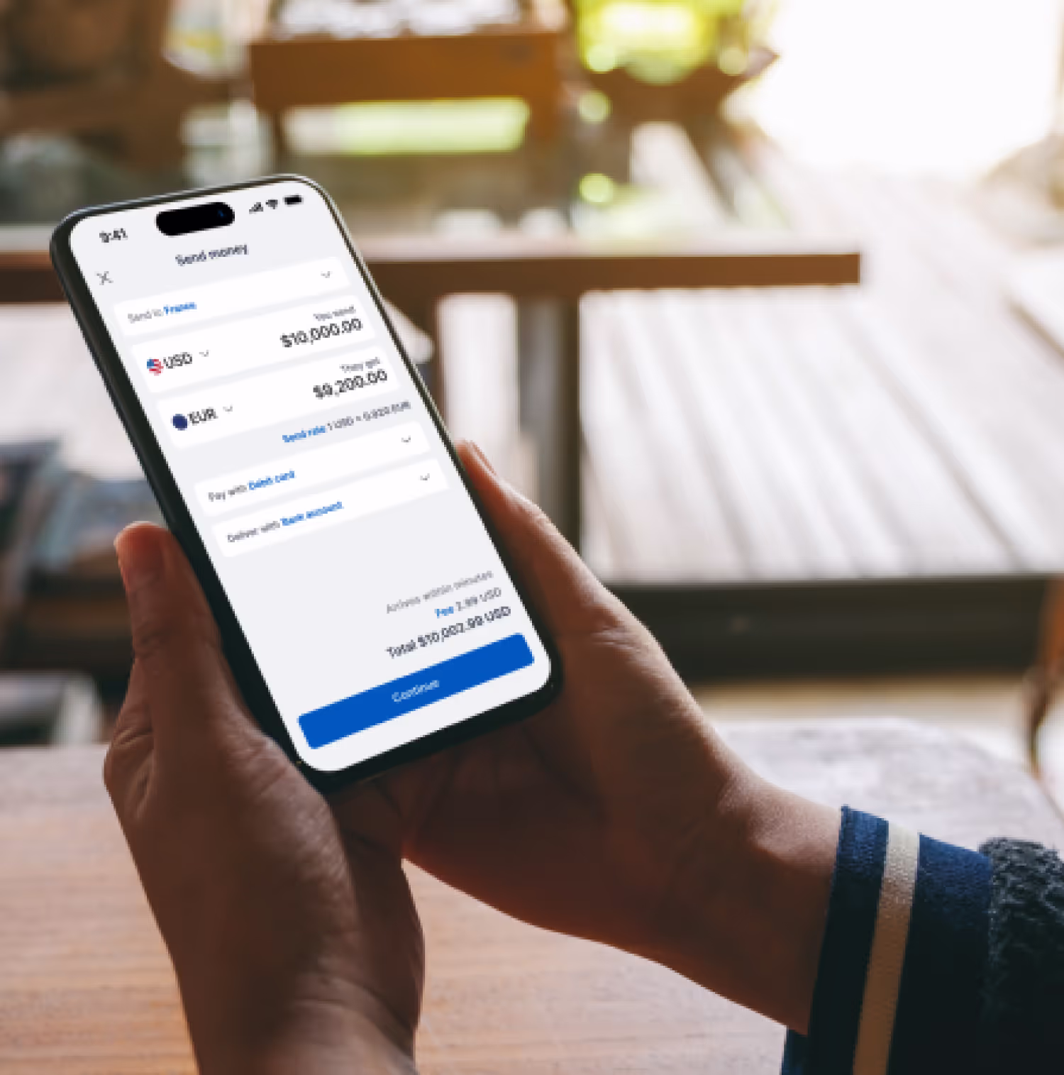 Hands holding a phone with money transfer interfaces